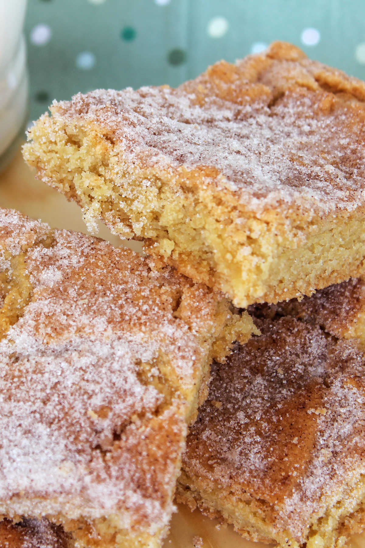 Pile of snickerdoodle bars with cinnamon sugar dusted on top.