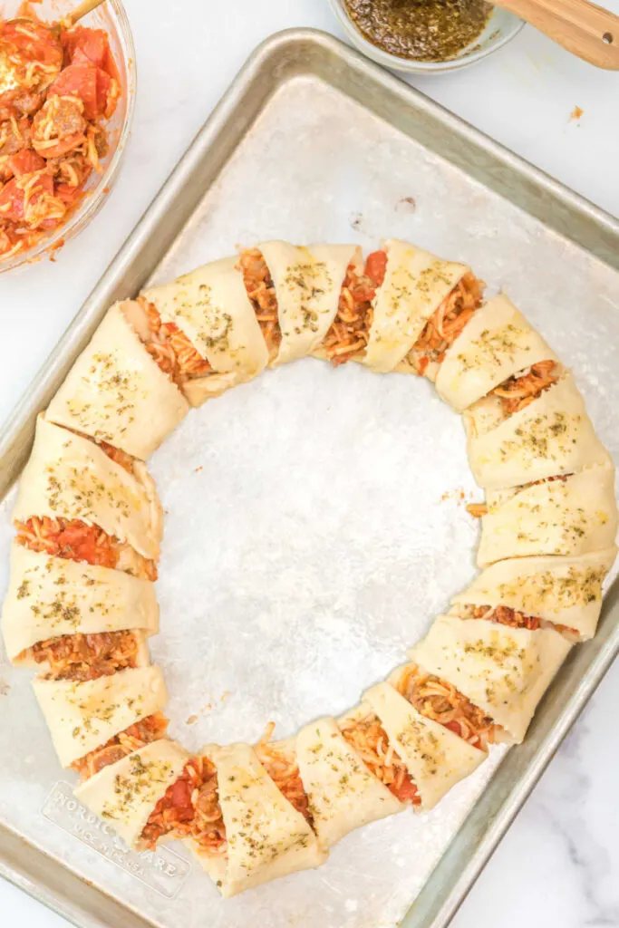 Assembled pizza crescent ring brushed with seasoned olive oil ready to bake.