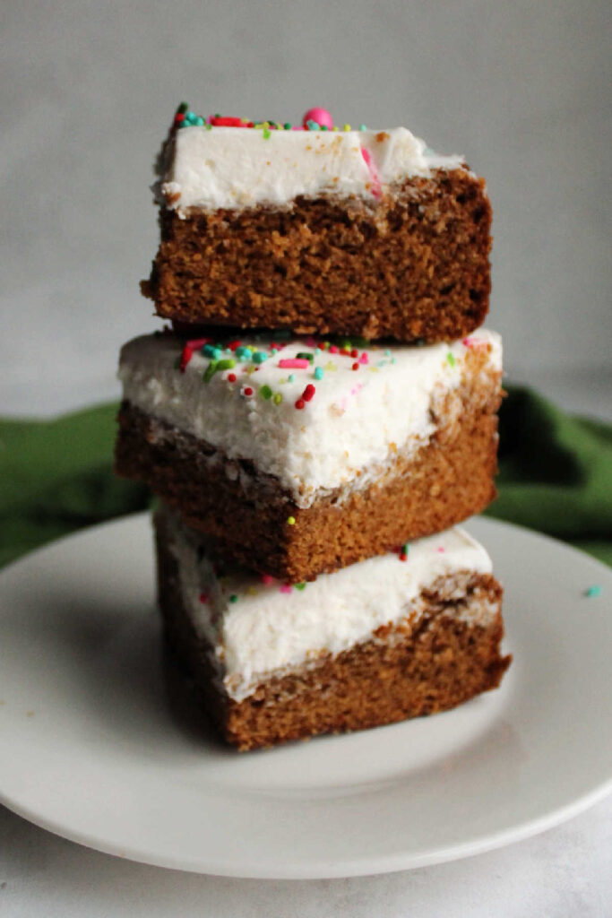 Stack of frosted gingerbread cookie bars with buttercream and sprinkles.