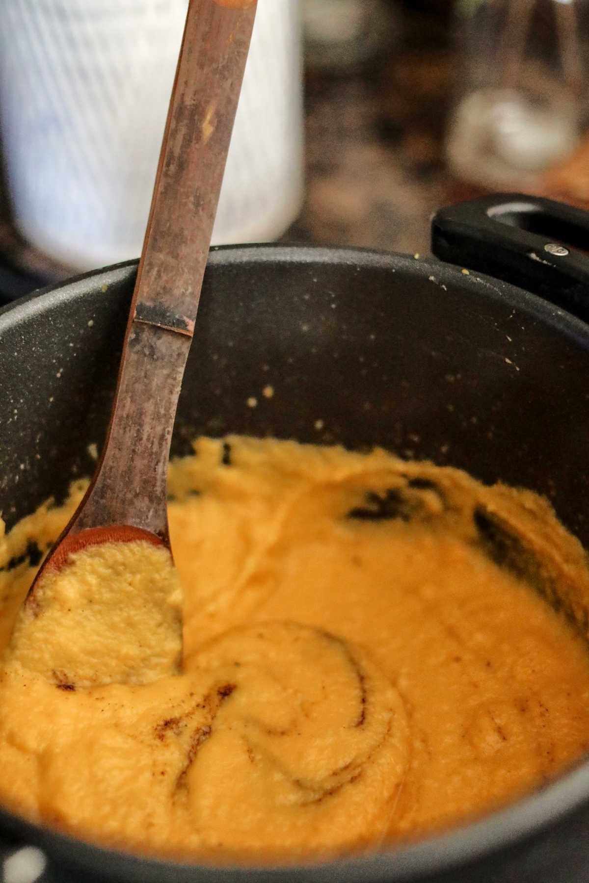 Stirring smooth butternut sauce in pan.