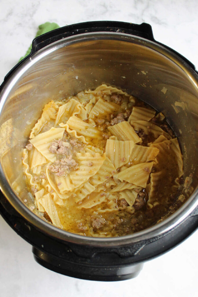 Cooked pasta with chicken broth and sausage in Instant Pot.