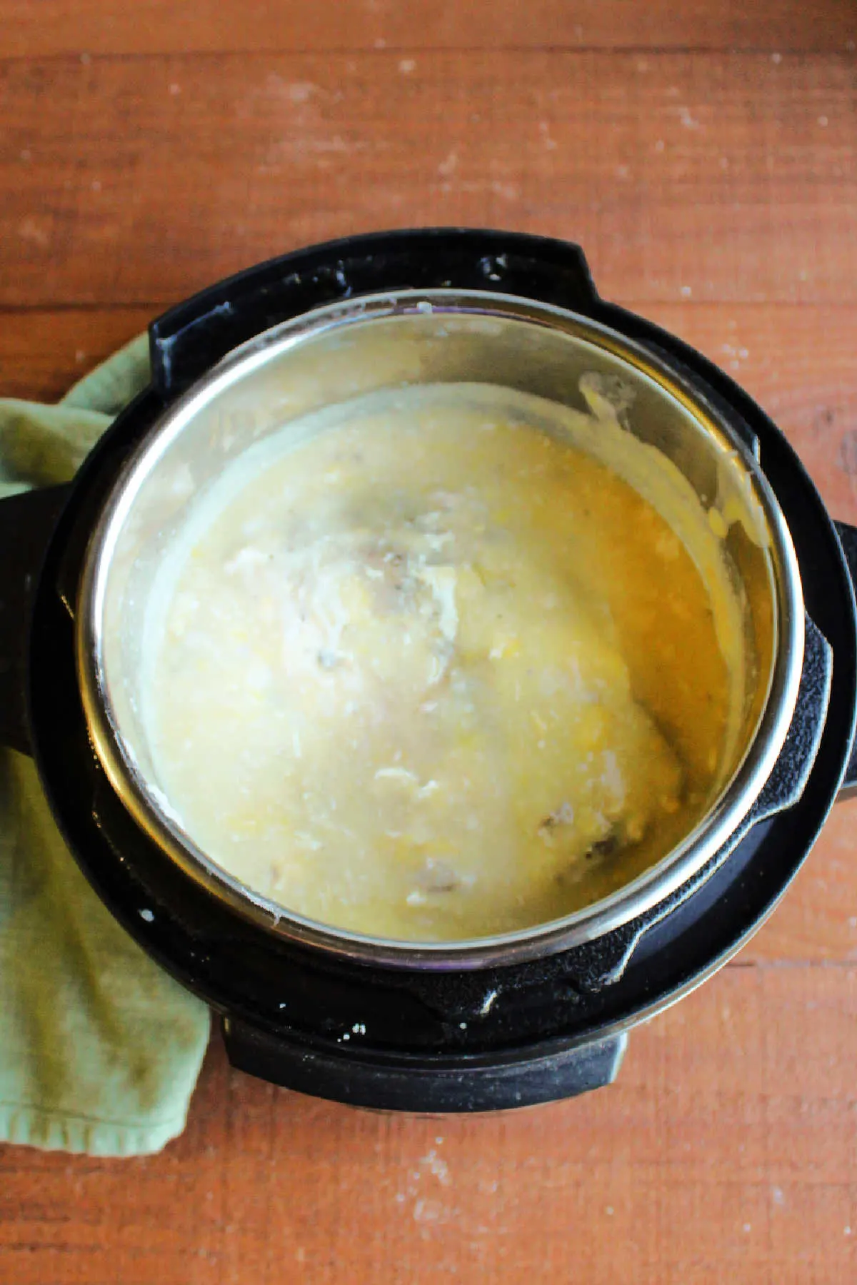 Pork loin cooked in creamy gravy inside slow cooker, ready to remove and slice. 