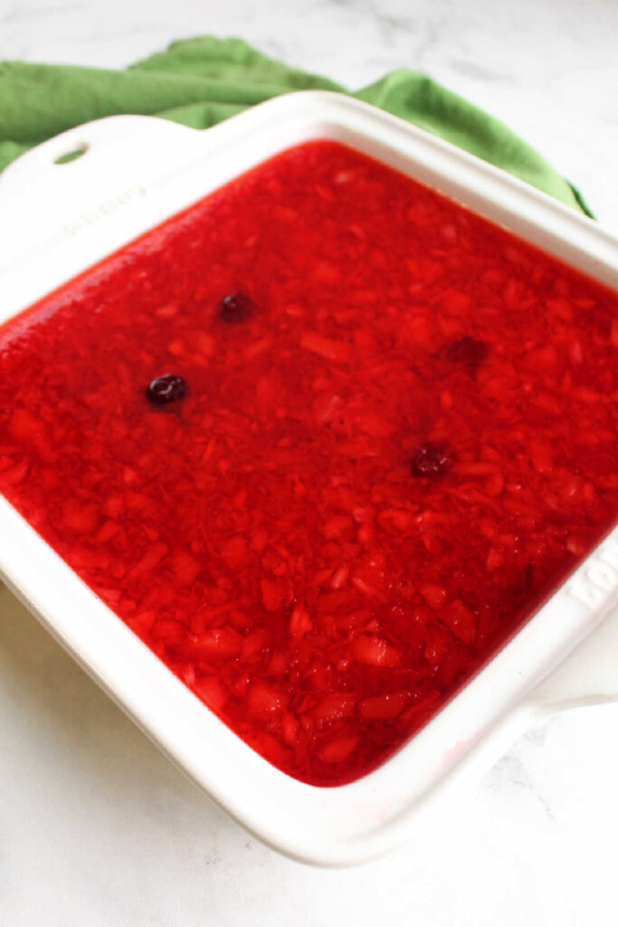 pan of cranberry jello salad with crushed pineapple, ready to go in the refrigerator to chill and set up.