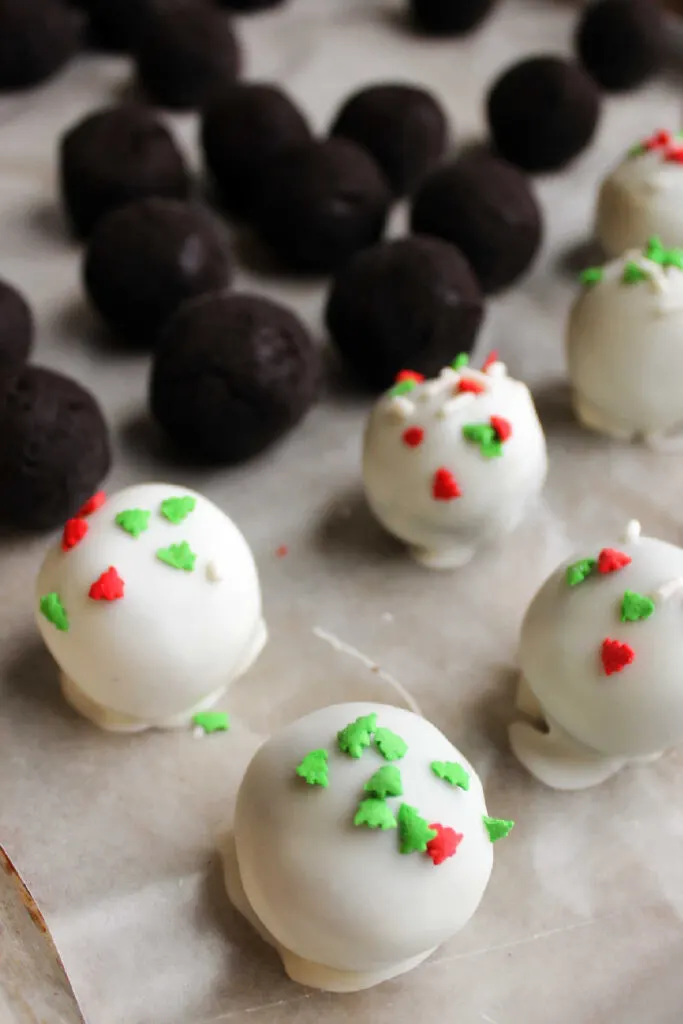 Dipping Oreo balls into melted white chocolate and adding sprinkles. 