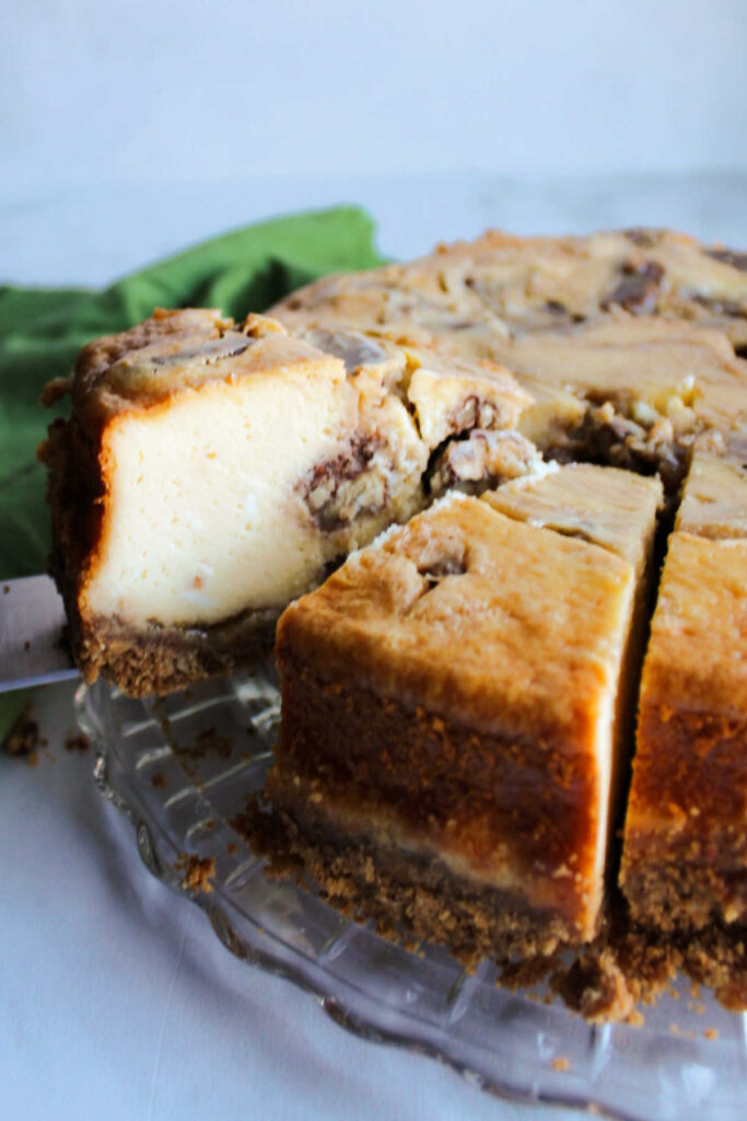 Lifting out slice of cheesecake with pecans and brown sugar swirled throughout. 