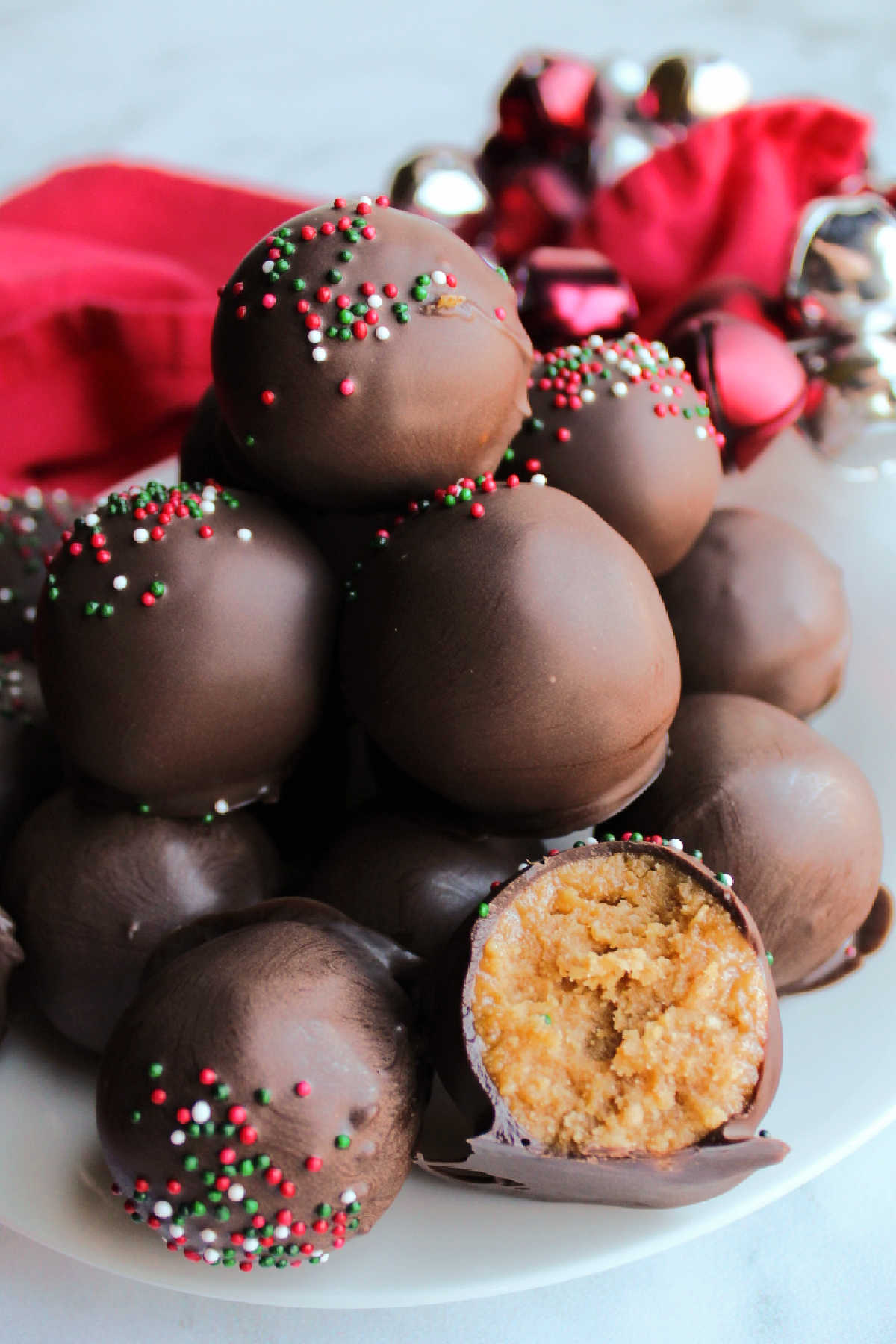 Pile of peanut butter truffles with one cut open to show the peanut butter center.