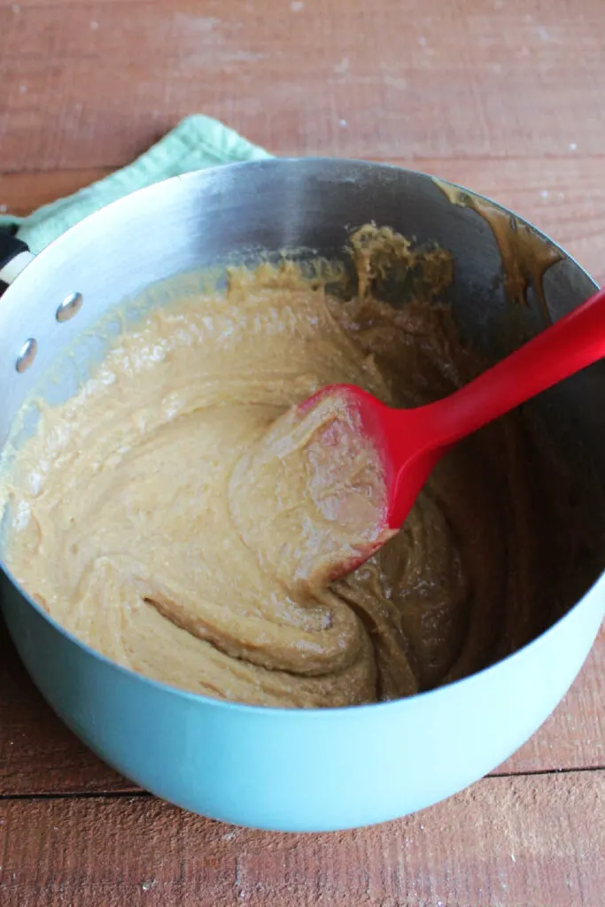 Cooked peanut butter, honey and sugar mixture in saucepan.