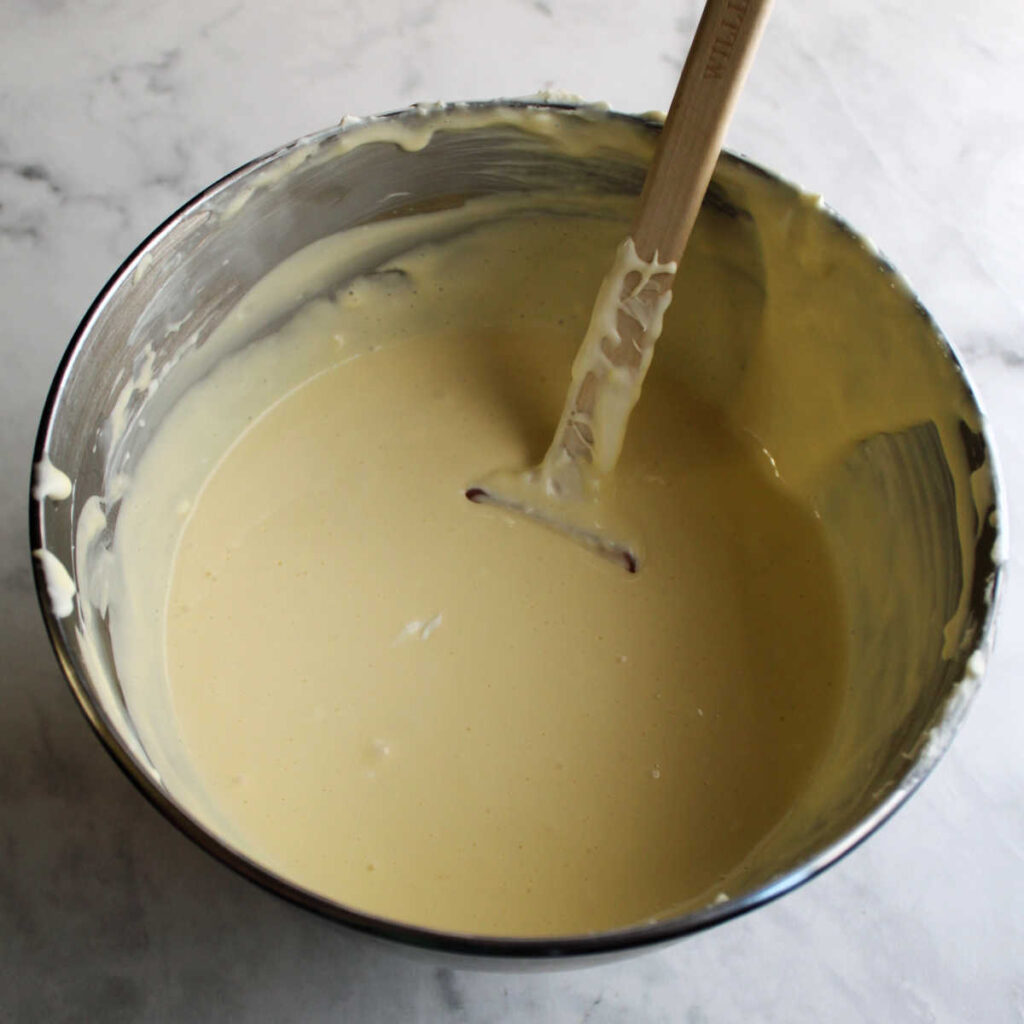 Mixing bowl filled with creamy sweetened condensed milk cheesecake mixture.