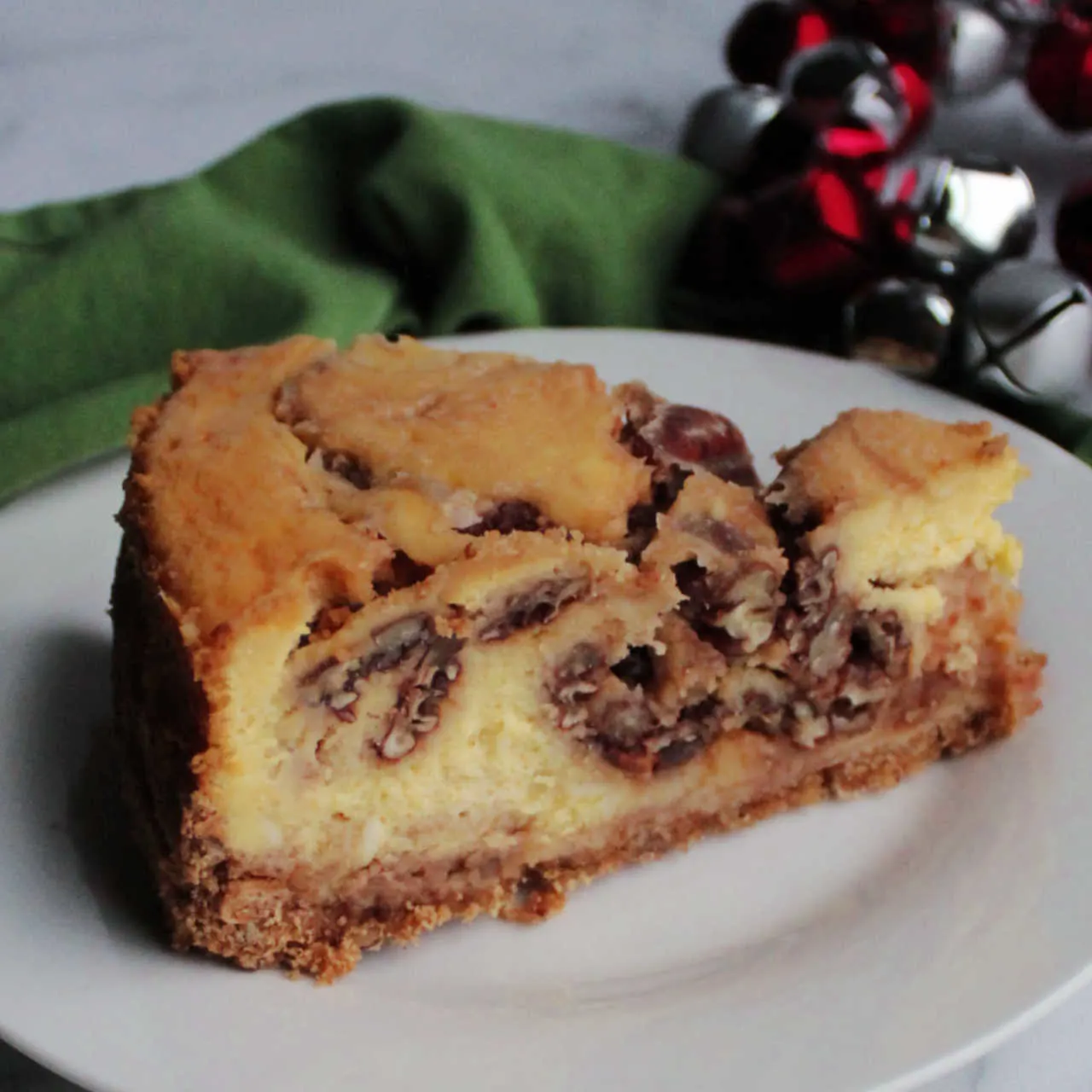 Slice of pecan pie cheesecake with brown sugar and pecan swirl.