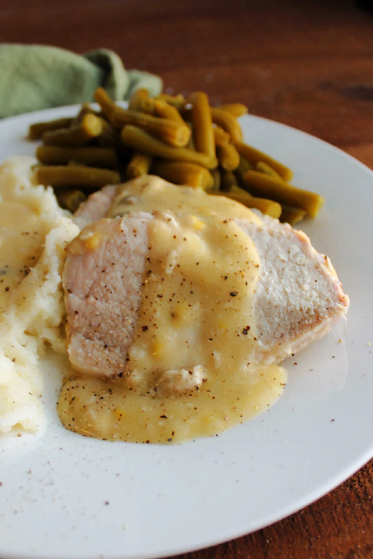 Close up of pork loin slices with creamy gravy over the top.