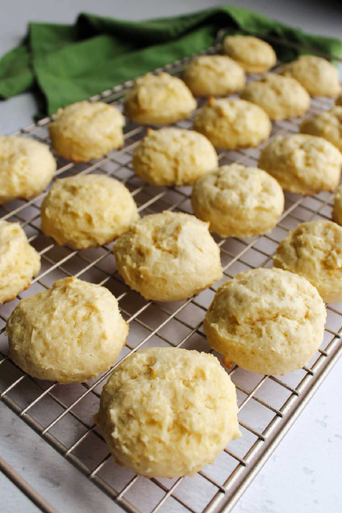 Puffy lemon cookies on wire cooling rack.