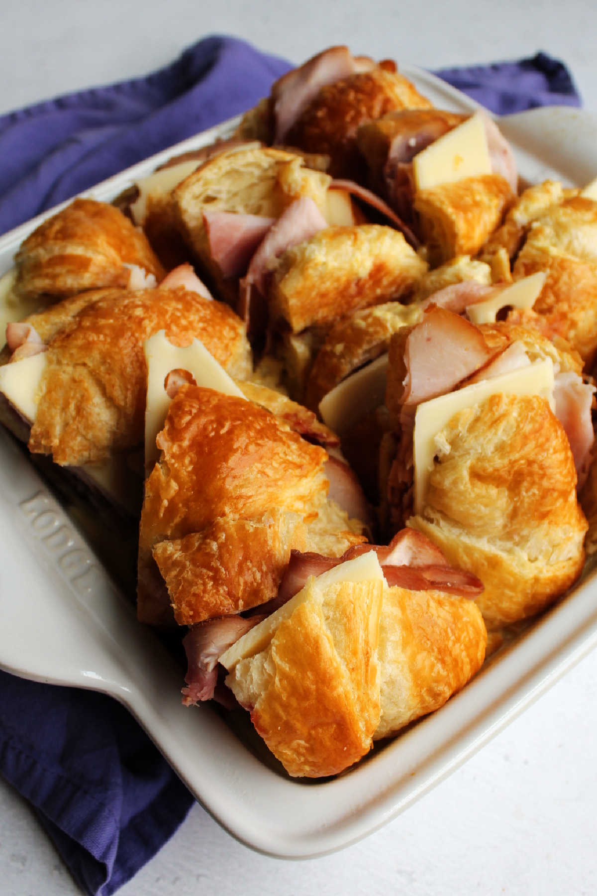 Ham, cheese and raspberry sandwiches arranged in baking dish.