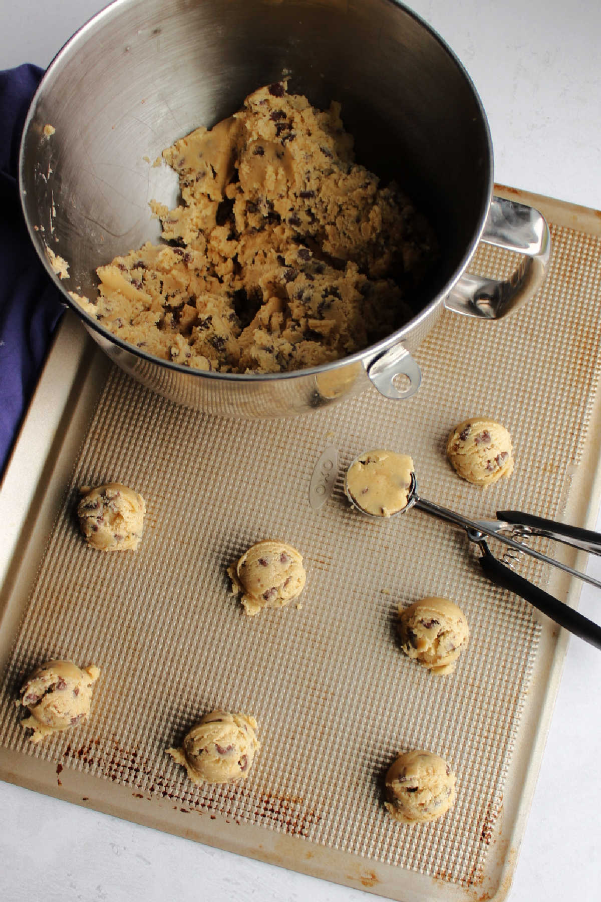 Scooping cookie dough onto baking sheet to bake. 