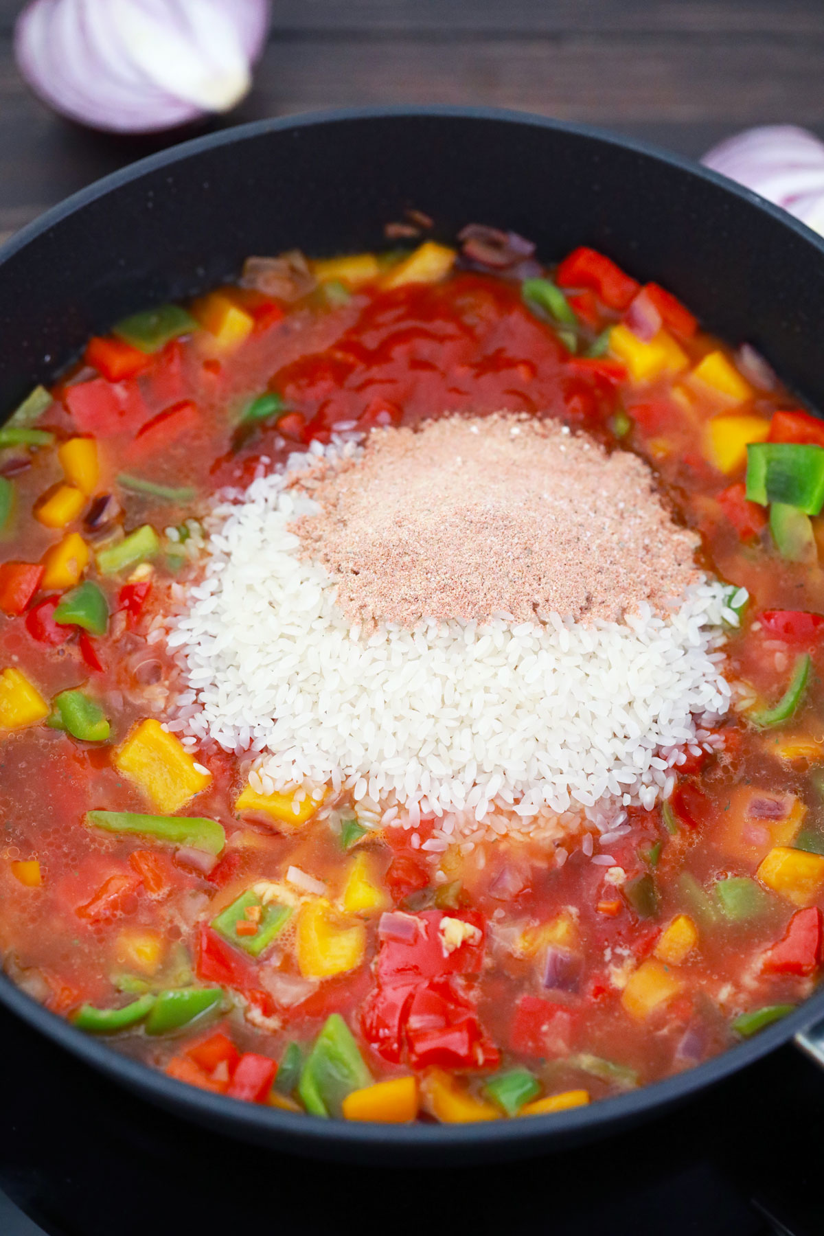 Adding rice to veggies in skillet.