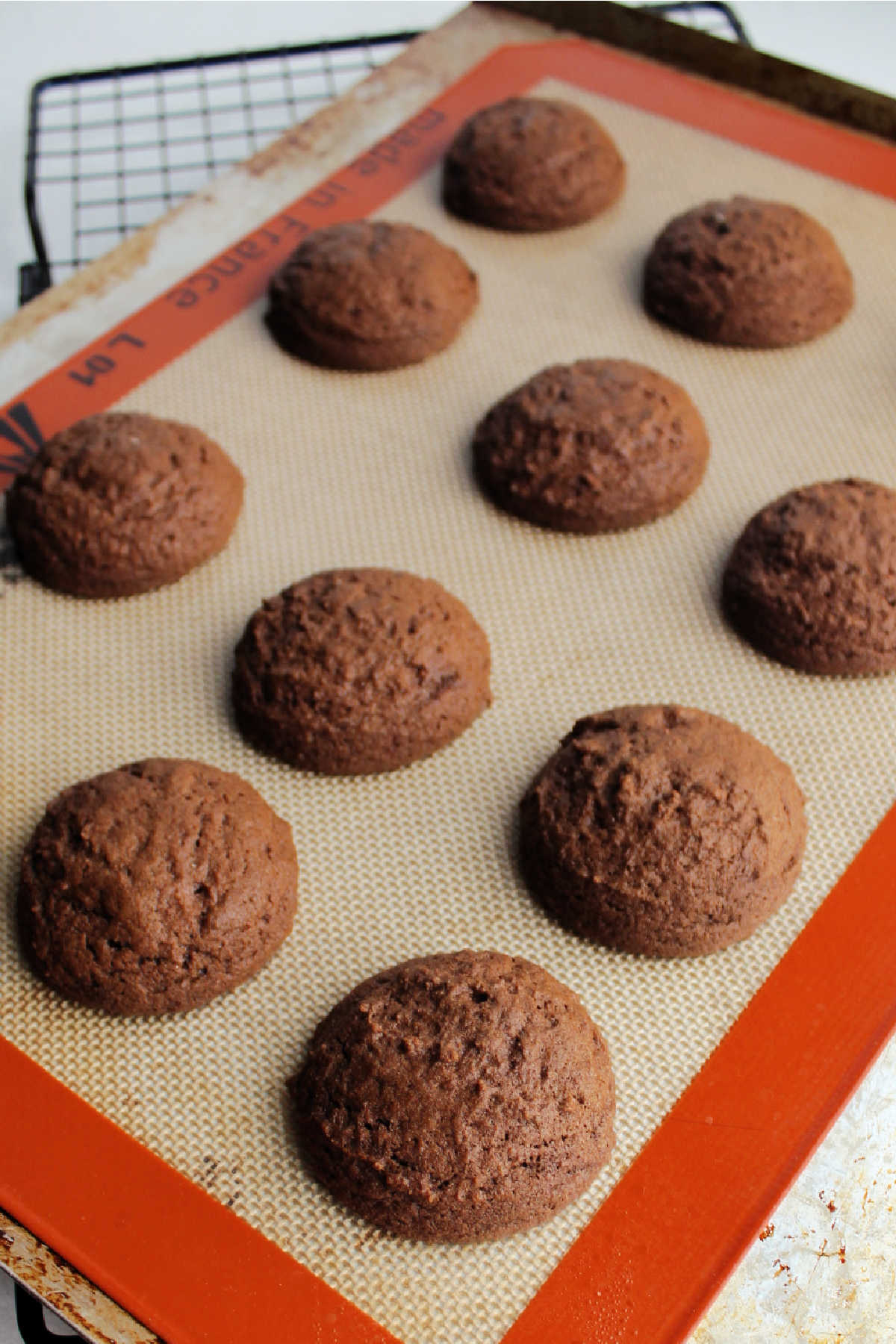 Thick chocolate cookies on sheet tray fresh from the oven.