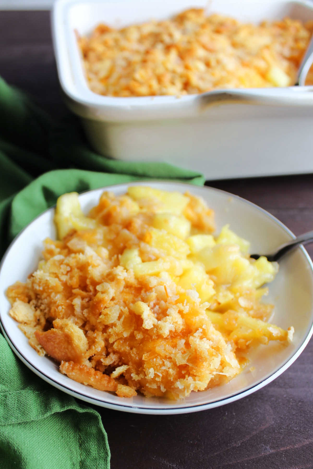 Small bowl filled with cheesy pineapple and cracker casserole. 