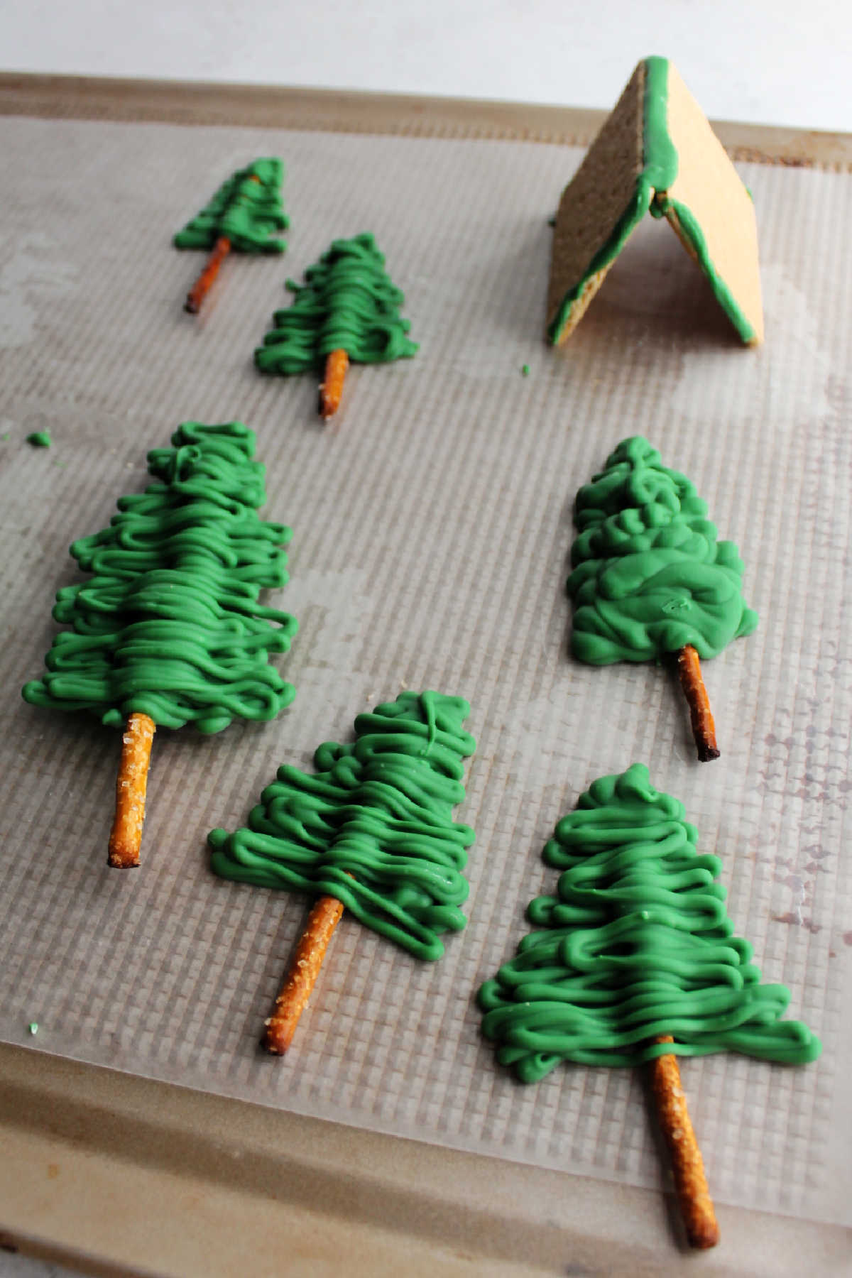Making trees out of pretzels and green chocolate