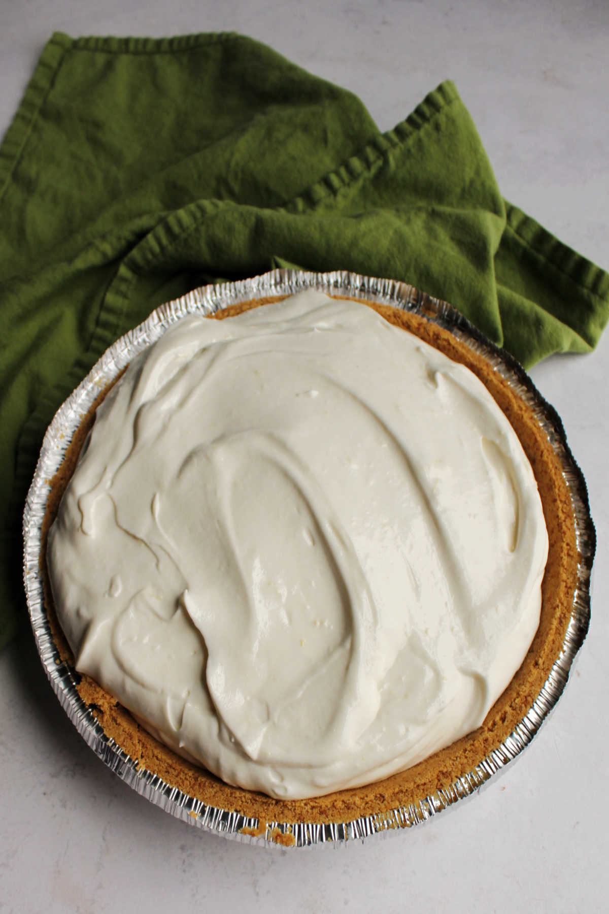 Whole creamy lemon pie, ready to be cut and served.