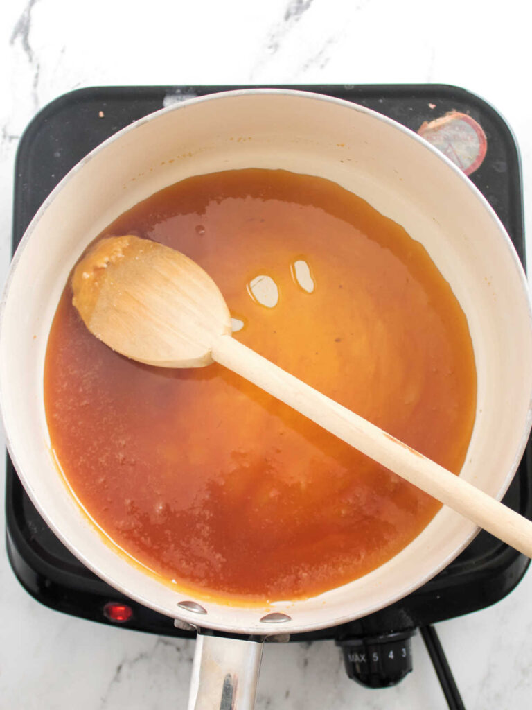 Saucepan with amber colored caramelized sugar waiting for butter and cream.