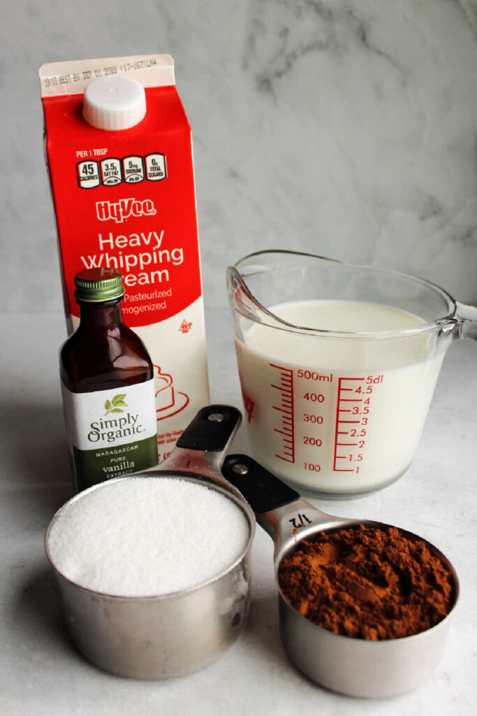 Cream, milk, sugar, vanilla, and cocoa powder ready to be made into ice cream.