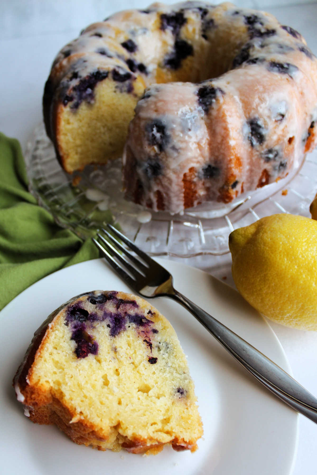 Slice of lemon blueberry cake on plate with fork with remaining