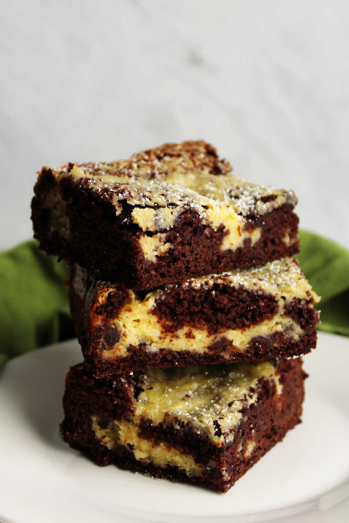 Pieces of chocolate chip gooey butter cake stacked on top of one another, ready to eat.