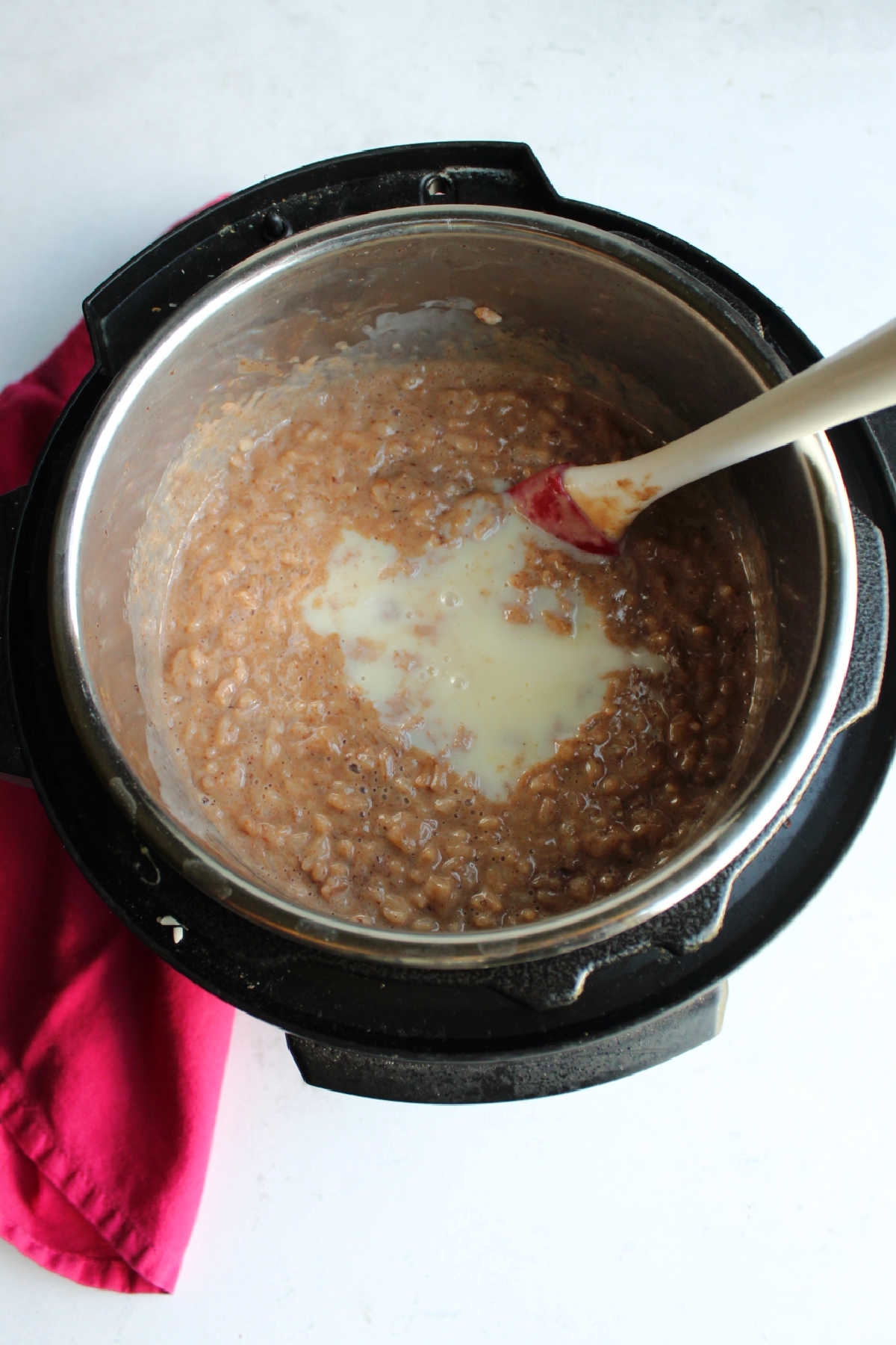 Cooked rice, milk and cocoa mixture in instant pot with condensed milk ready to be stirred in.