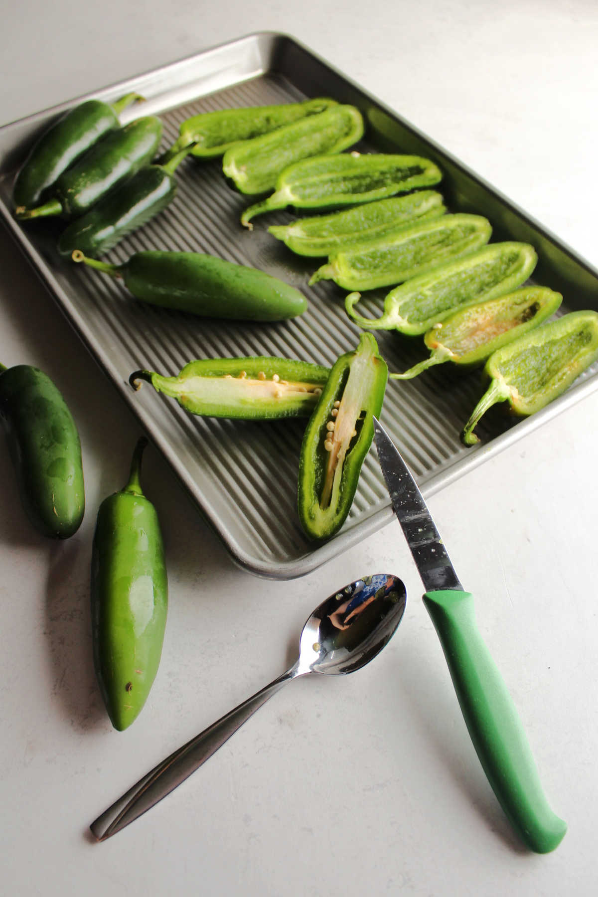 Cutting jalapenos in half and cleaning out the centers.
