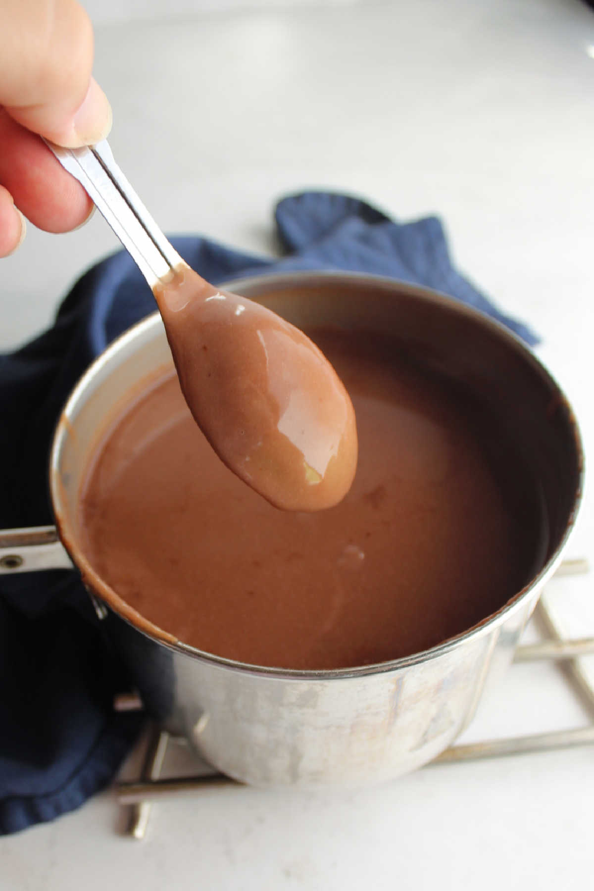 Warm thickened chocolate pudding coating the back of a spoon.