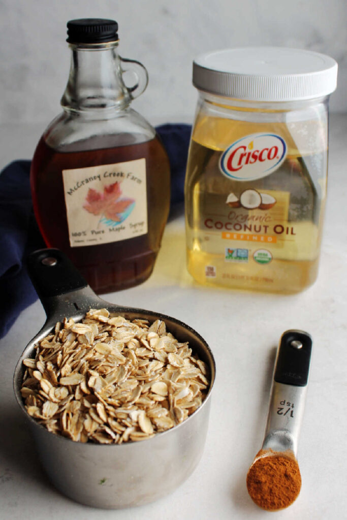Coconut oil, maple syrup, cinnamon and oats ready to be made into quick and easy granola.
