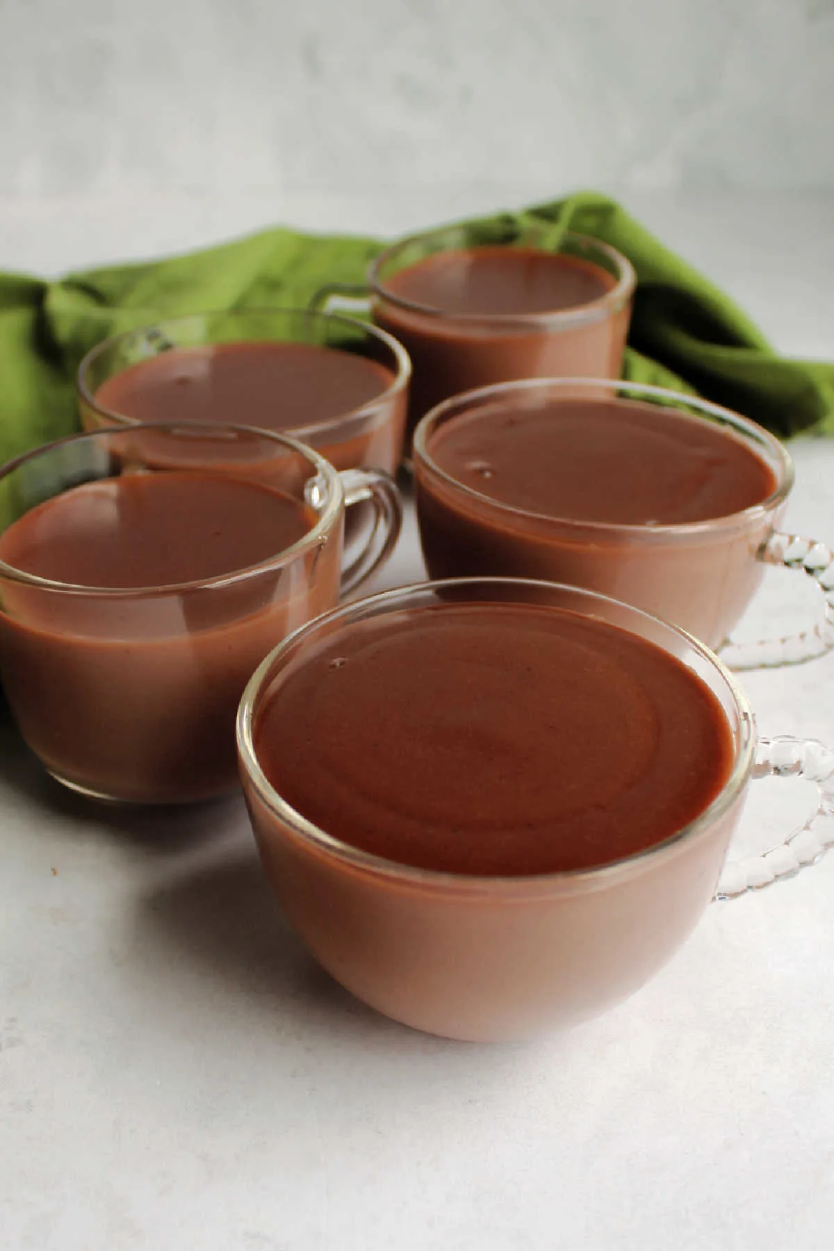 Glass mugs filled with hot chocolate pudding.