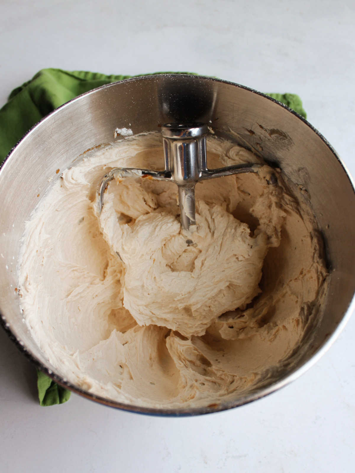 Mixing bowl filled with apple butter buttercream frosting and paddle attachement.