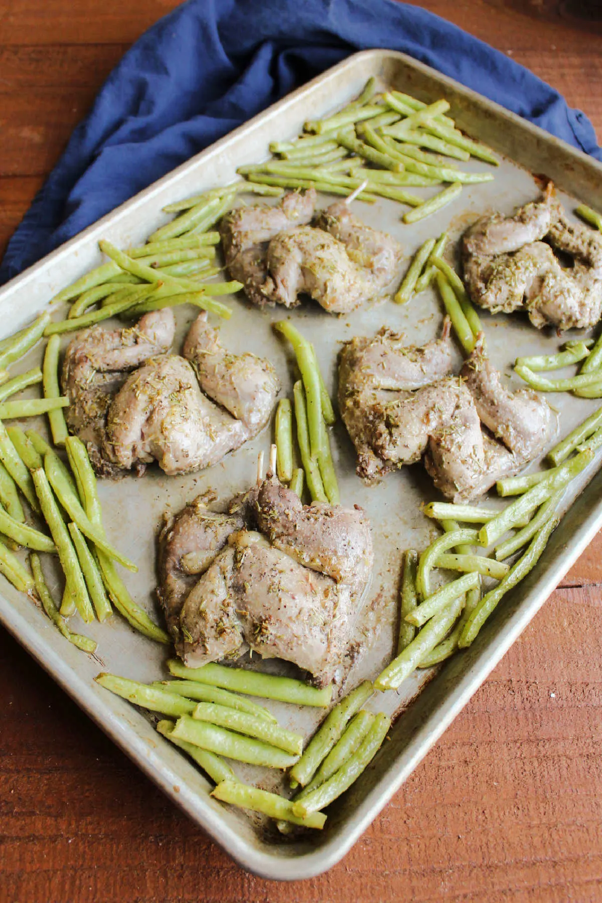 Roasted quail and green beans on sheet pan, ready to serve.