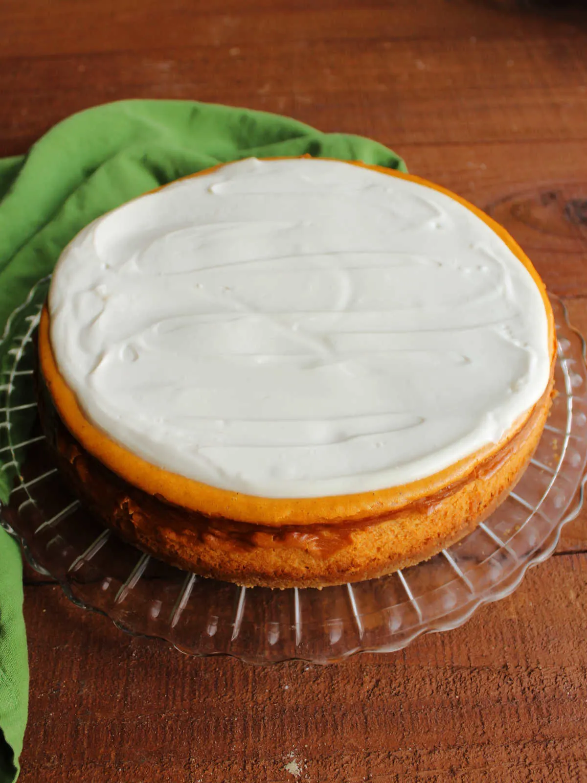 Whole pumpkin cheesecake with sour cream topping spread over the top.