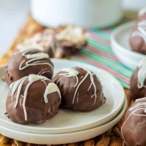 Plate of chocolate dipped martha washington candies with white chocolate drizzled on top.