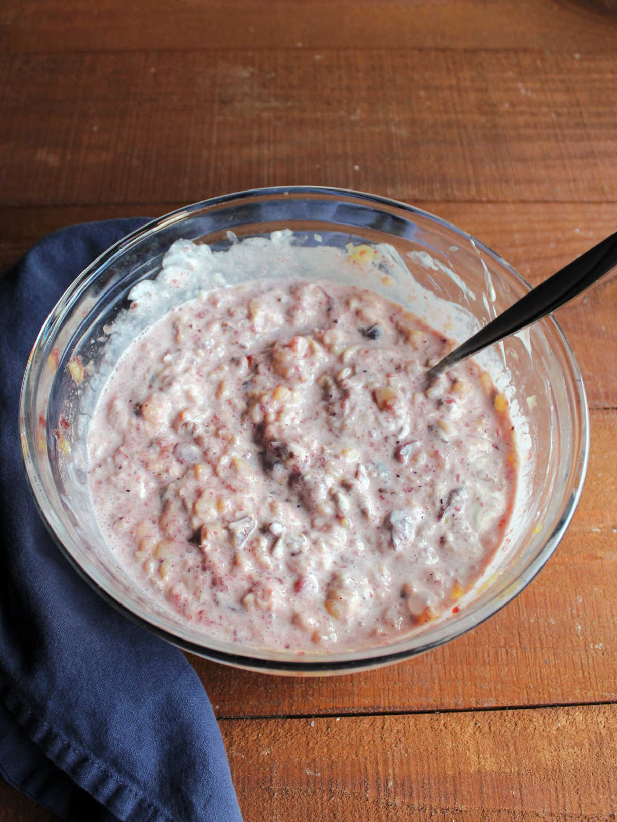 Mixing bowl filled with creamy cranberry salad mixture.