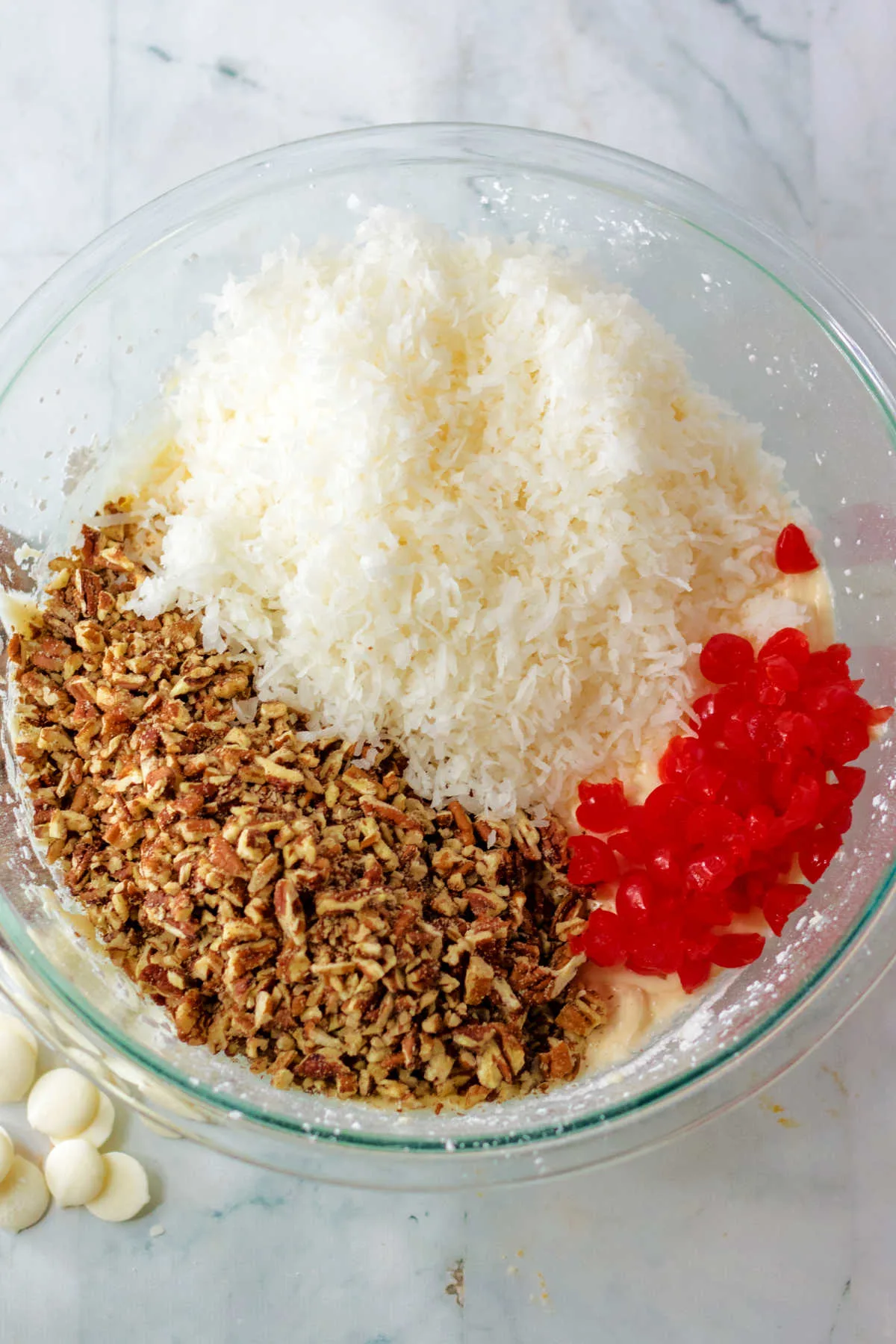 adding shredded coconut, chopped cherries and pecan bits to the butter and powdered sugar mixture.