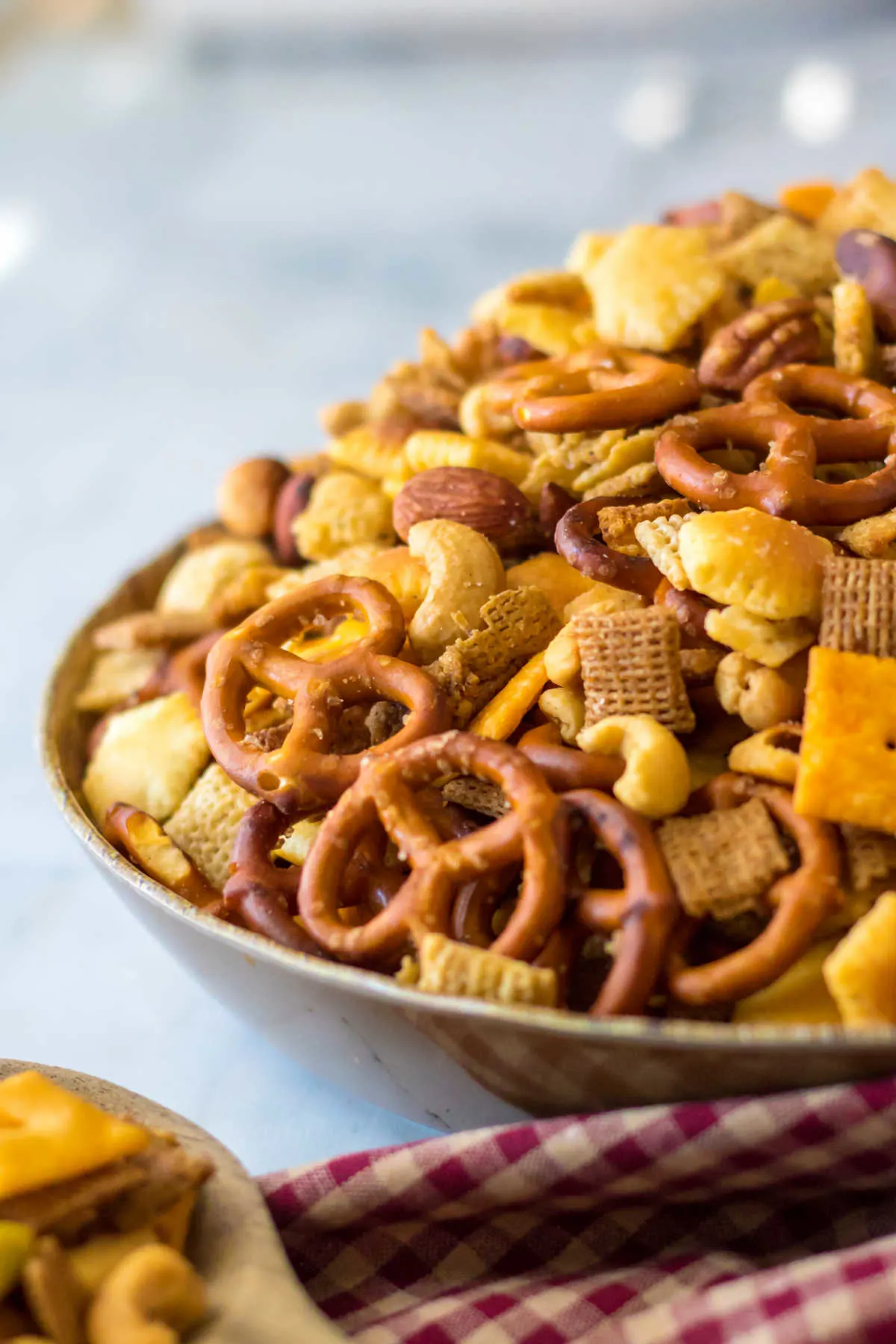 Side view of a serving bowl piled high with crocktpot chex mix.