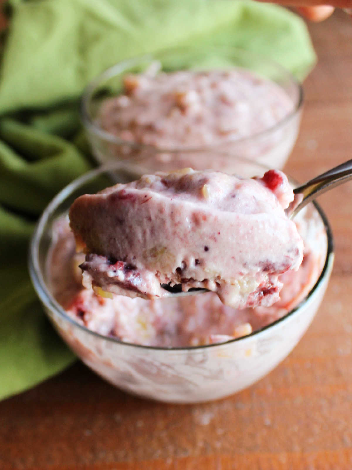 Spoonful of frozen cranberry pineapple salad showing creamy texture with small chunks.