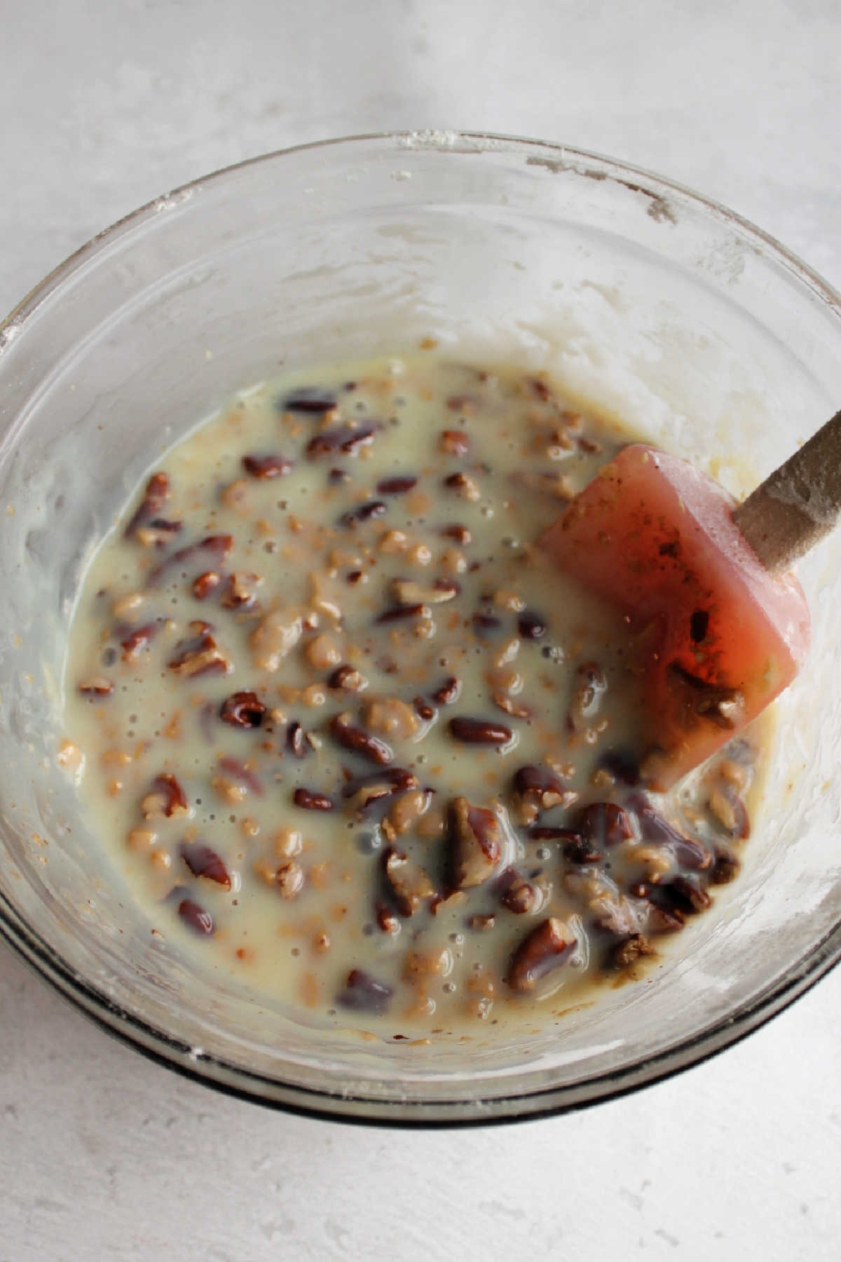 Bowl of condensed milk, pecans and toffee bits.