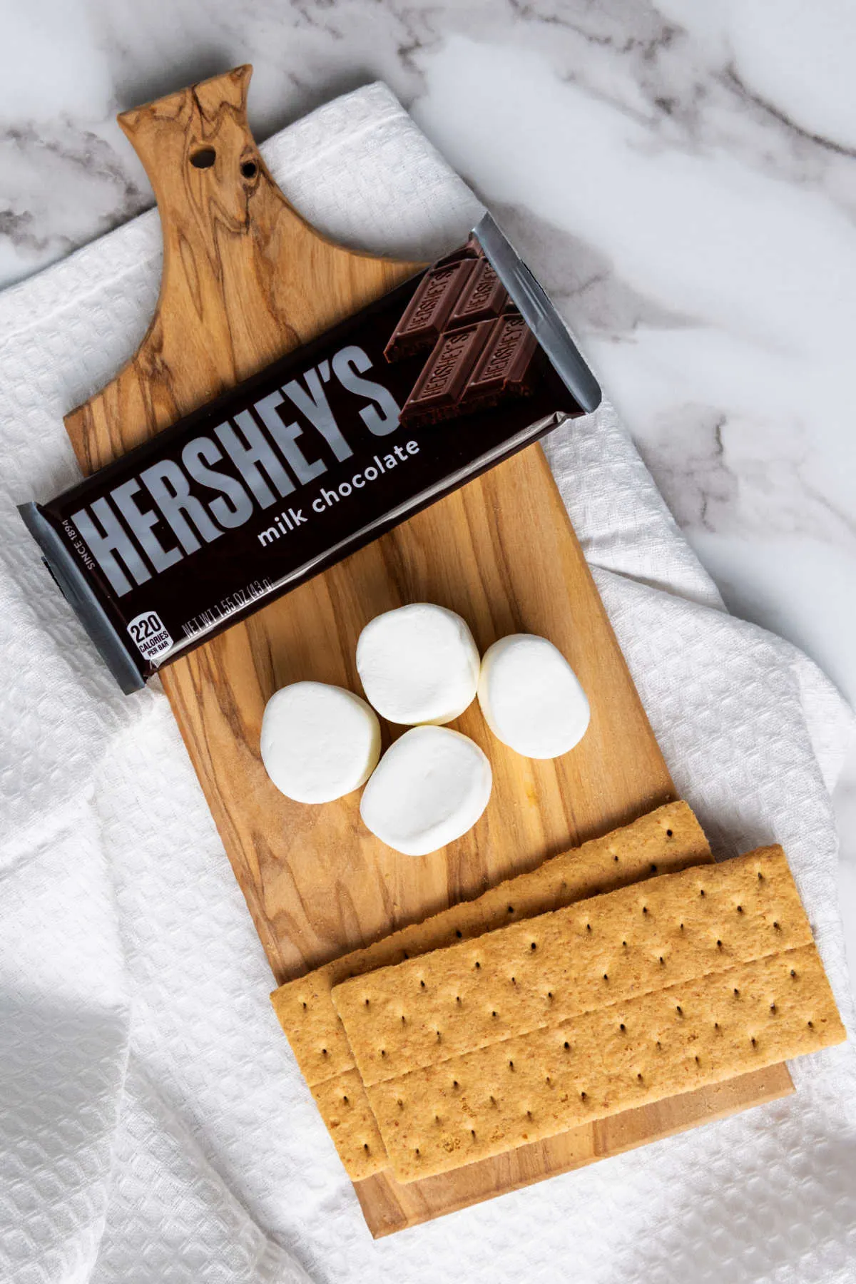 Ingredients: Hershey's bars, marshmallows and graham crackers ready to be made into air fryer smores.