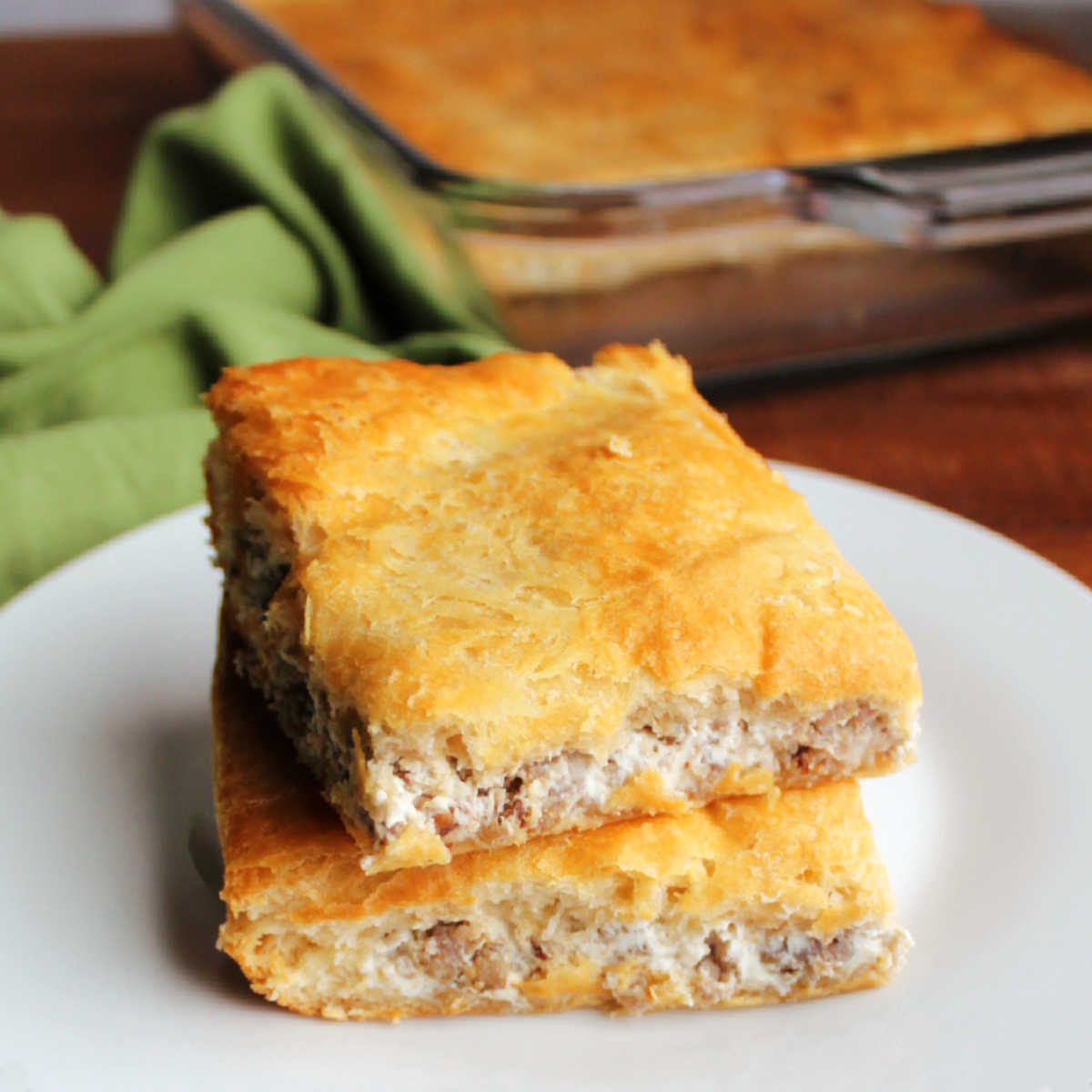 Two squares of bars with golden crescent layers on the top and bottom with a creamy sausage filling in between.