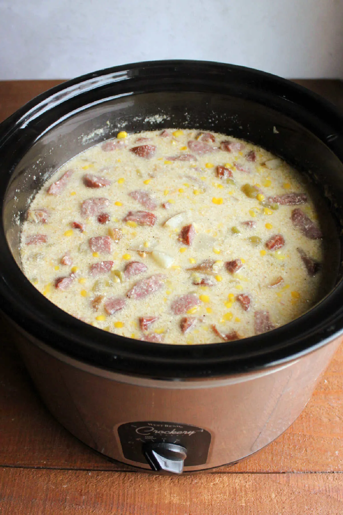 Slow cooker filled with cooked chowder showing creamy broth and lots of chunks.