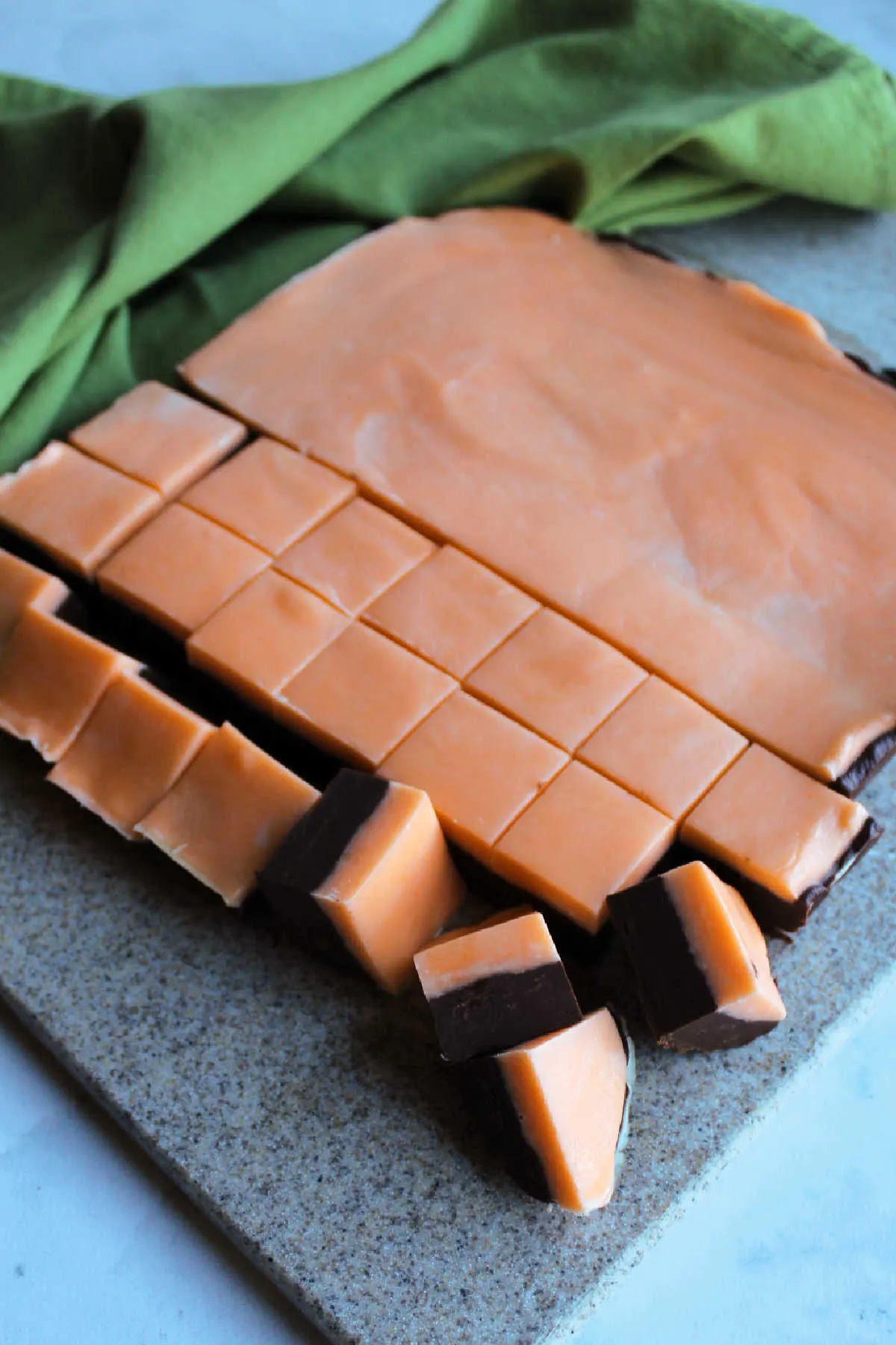 Cutting a batch of layered chocolate orange fudge into small squares.