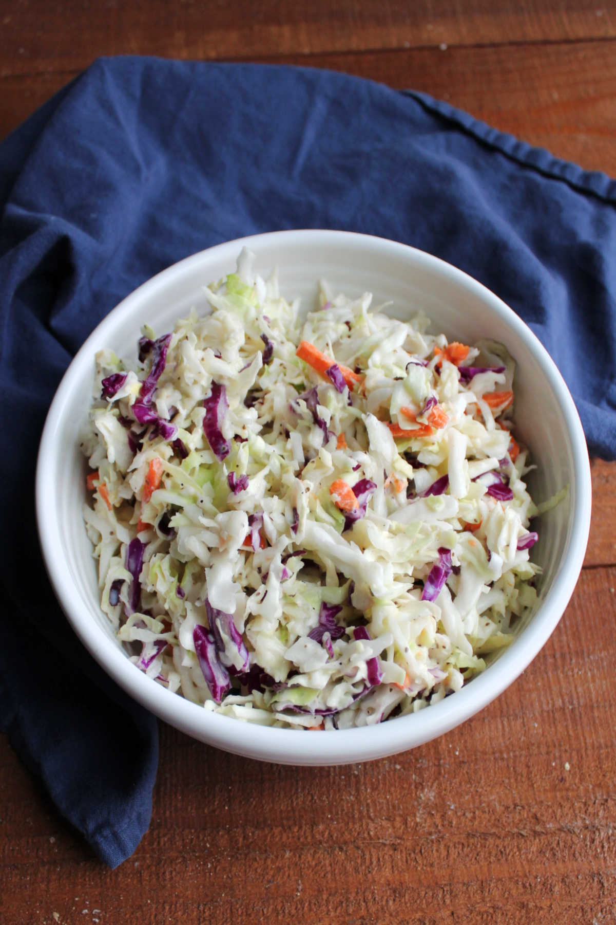 Serving bowl filled with coleslaw dressed with a creamy homemade condensed milk dressing.