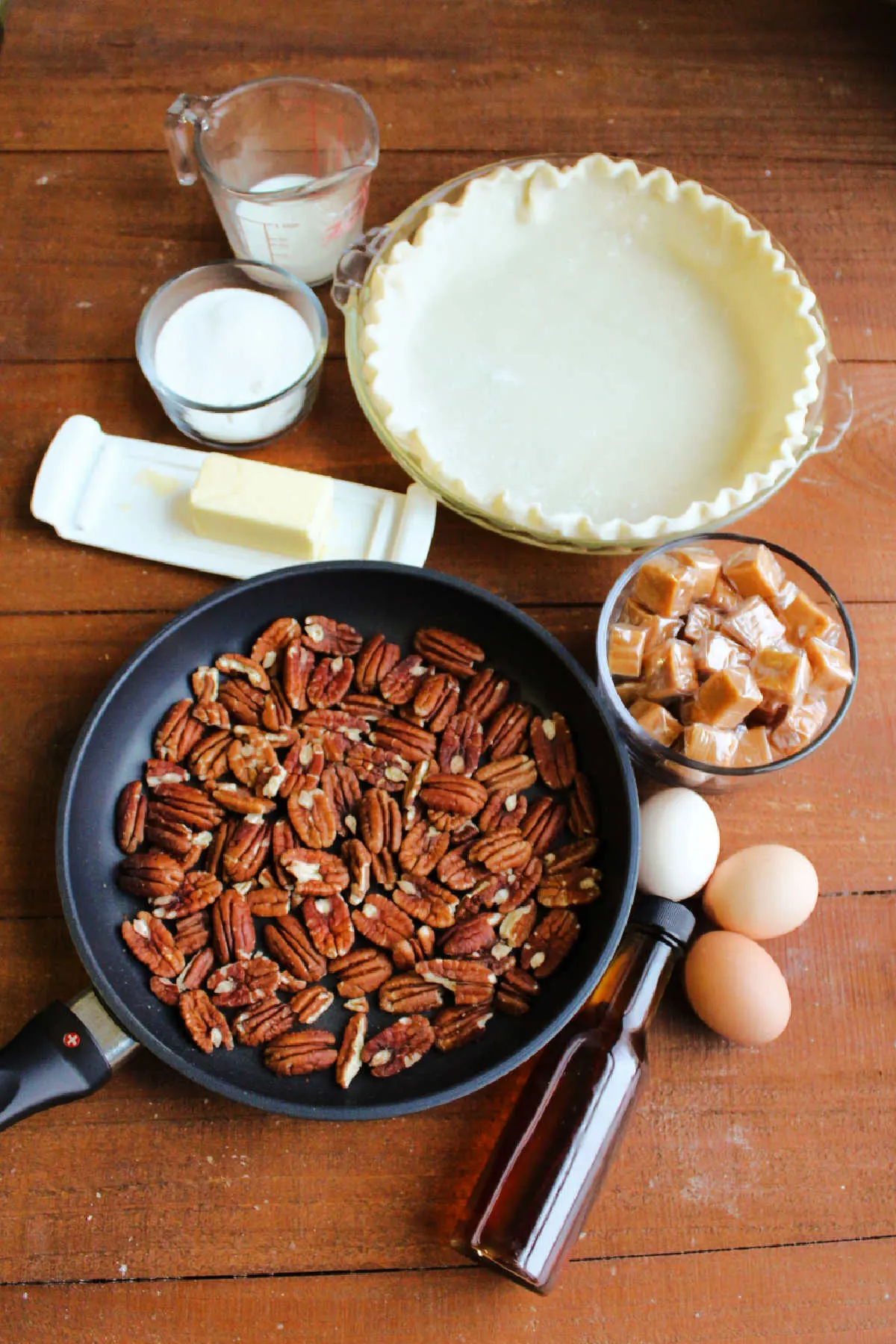 Ingredients for pie: pecans, butter, sugar, milk, pie crust, caramels, eggs and vanilla. 