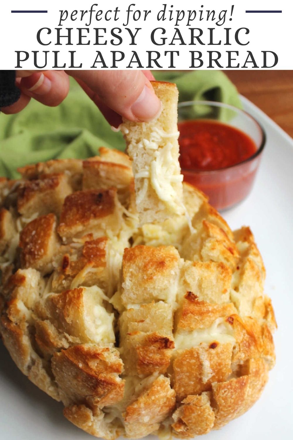 Cheesy garlic pull apart bread is like the best garlic bread you've ever had. You can pull cheesy chunks of bread out of a sourdough loaf and dip them in marinara for a fun snack, appetizer or side dish to your favorite pasta meal.