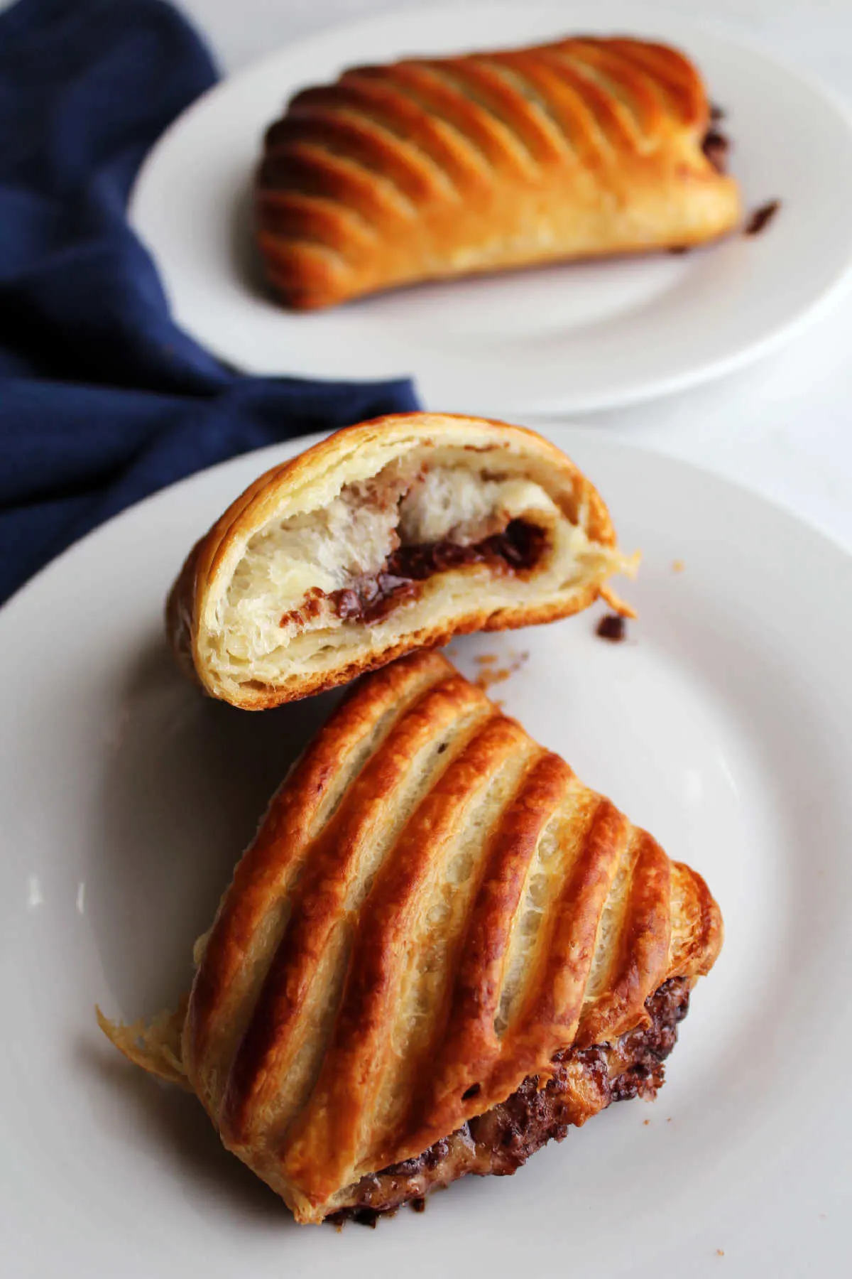 Inside of a freshly baked chocolate croissant with golden brown outside, flaky layers and melty chocolate in the middle.