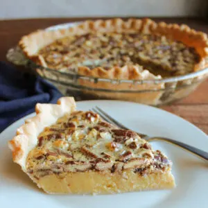 Slice of pie showing smooth sweetened condensed milk and brown sugar filling topped with toasted pecans.