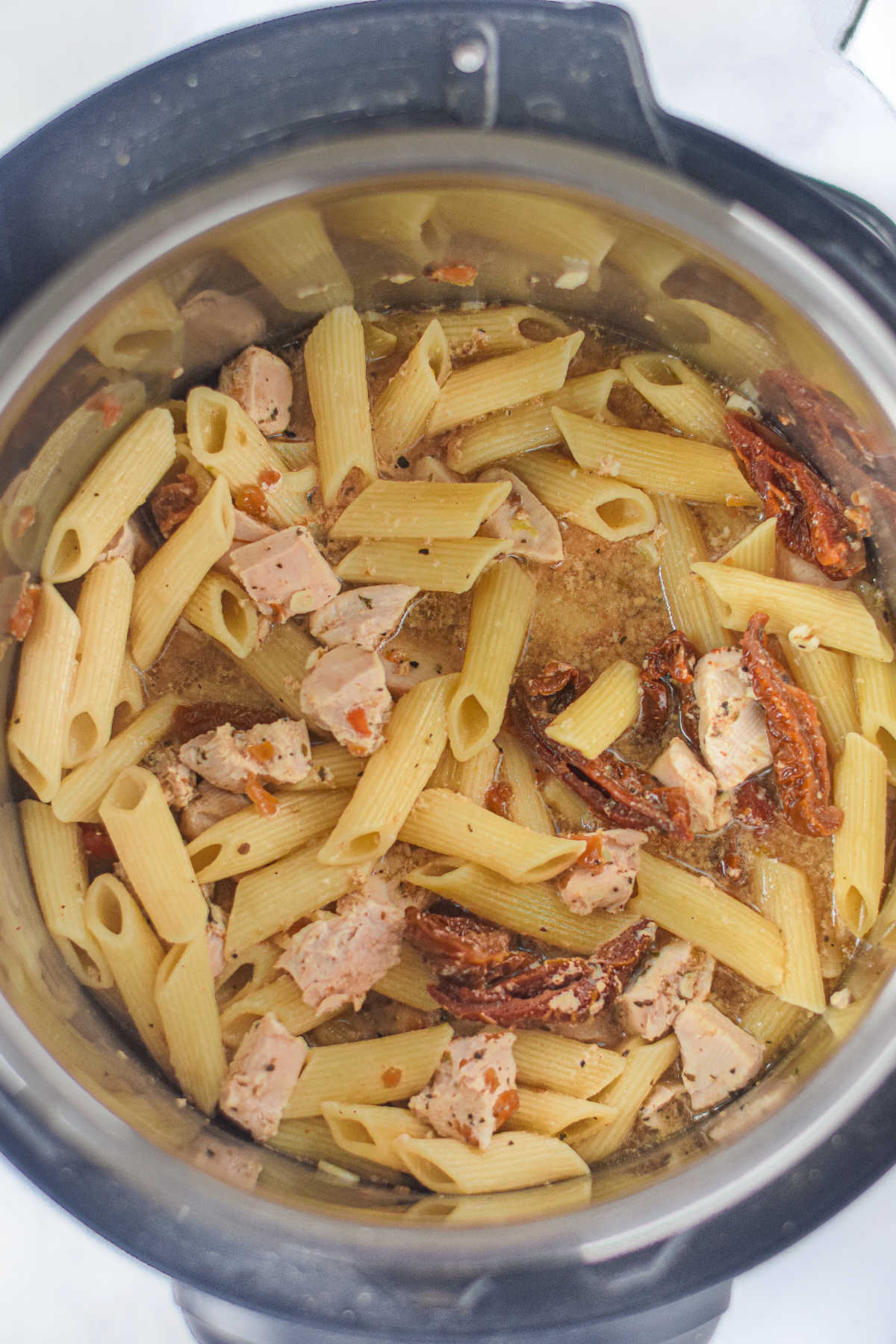 Cooked chicken and pasta mixture in instant pot.